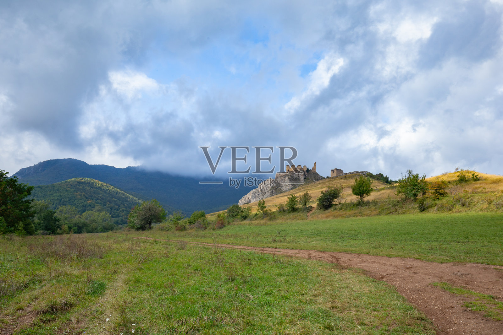 一条通往特兰西瓦尼亚中部阿普塞尼山脉山顶上的特拉斯考要塞的土路，在一个云雾缭绕的秋日里俯瞰着周围的群山照片摄影图片