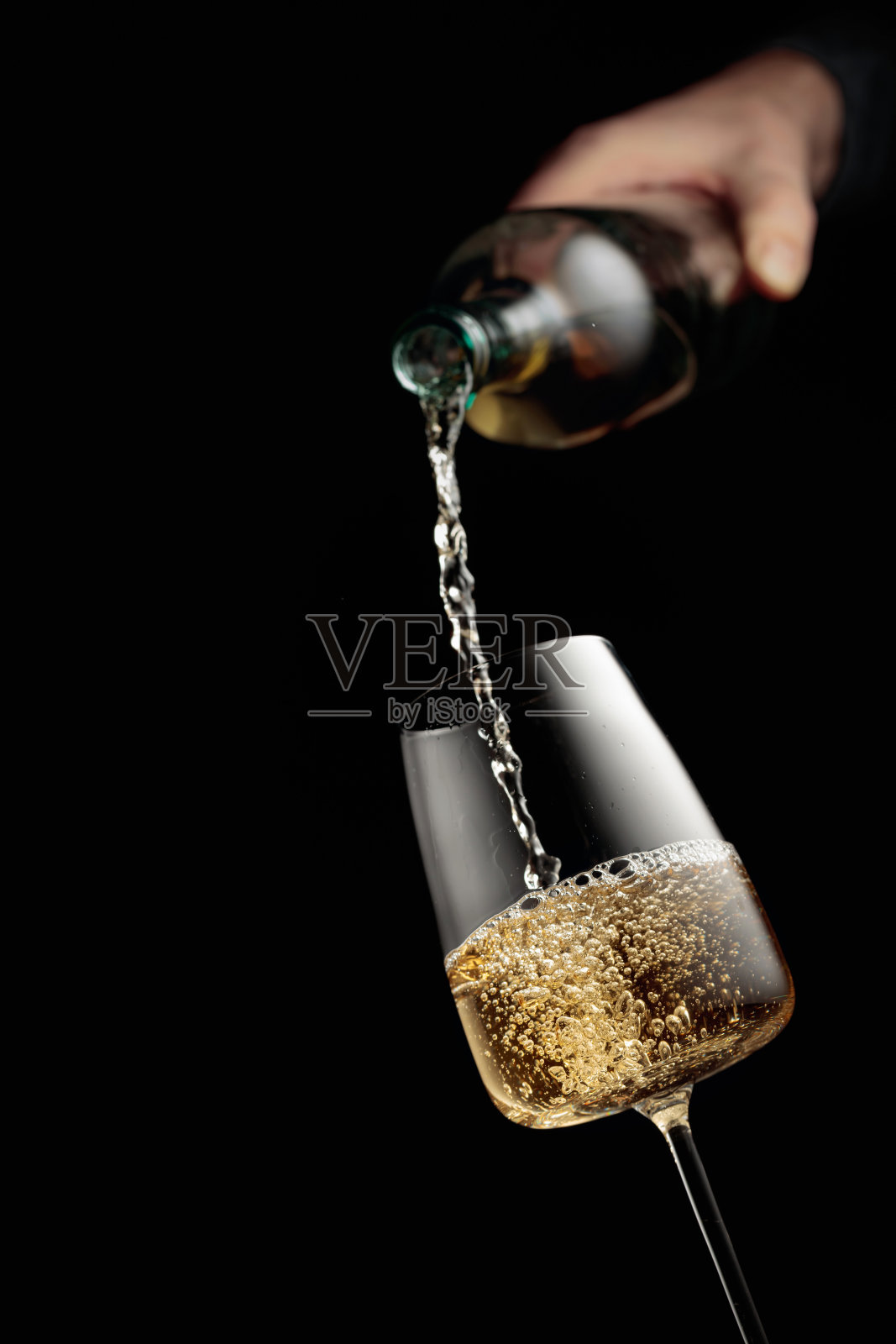 将白葡萄酒倒入高脚杯。照片摄影图片