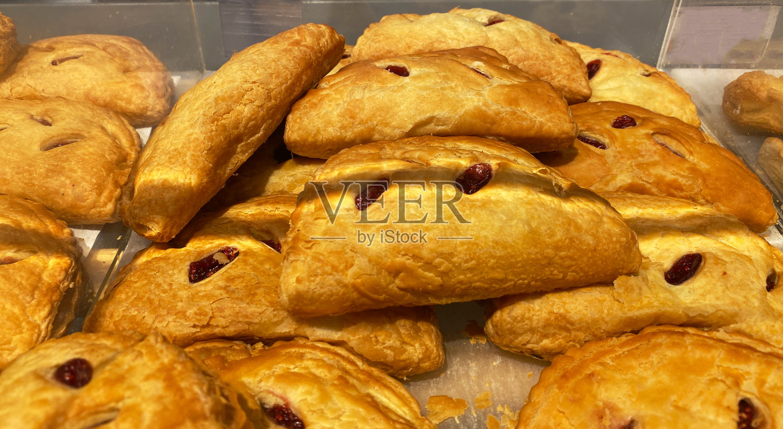 在面包店柜台出售的新鲜出炉的甜面包的特写照片摄影图片