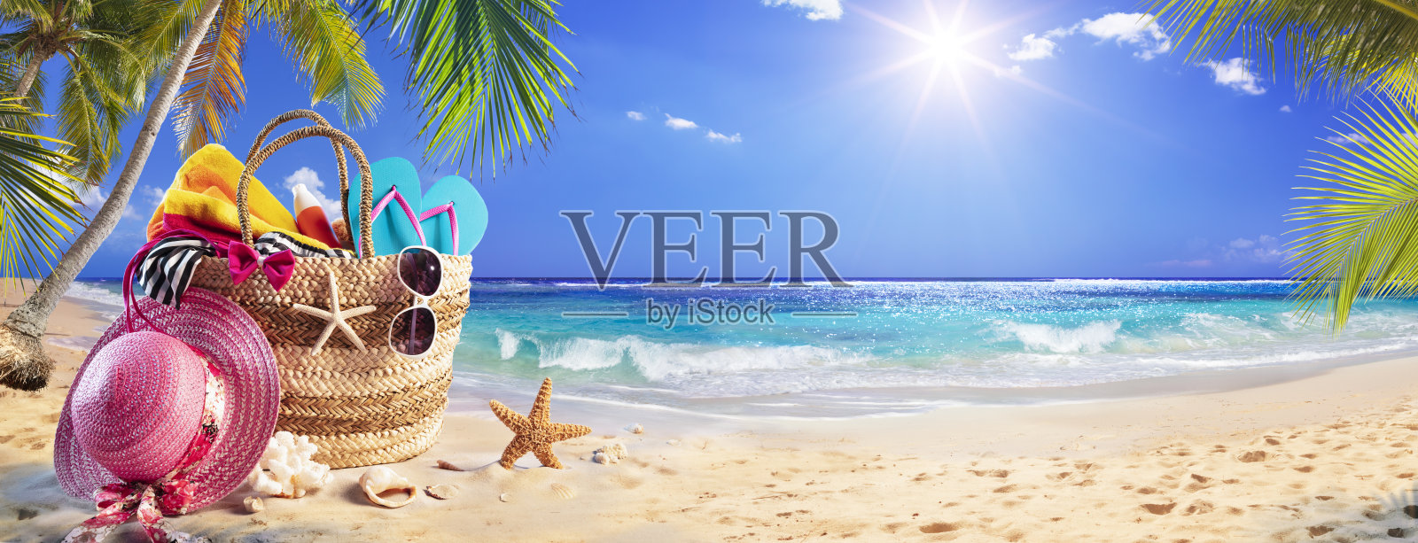 沙滩包在热带沙滩上的棕榈树和阳光明媚的大海照片摄影图片