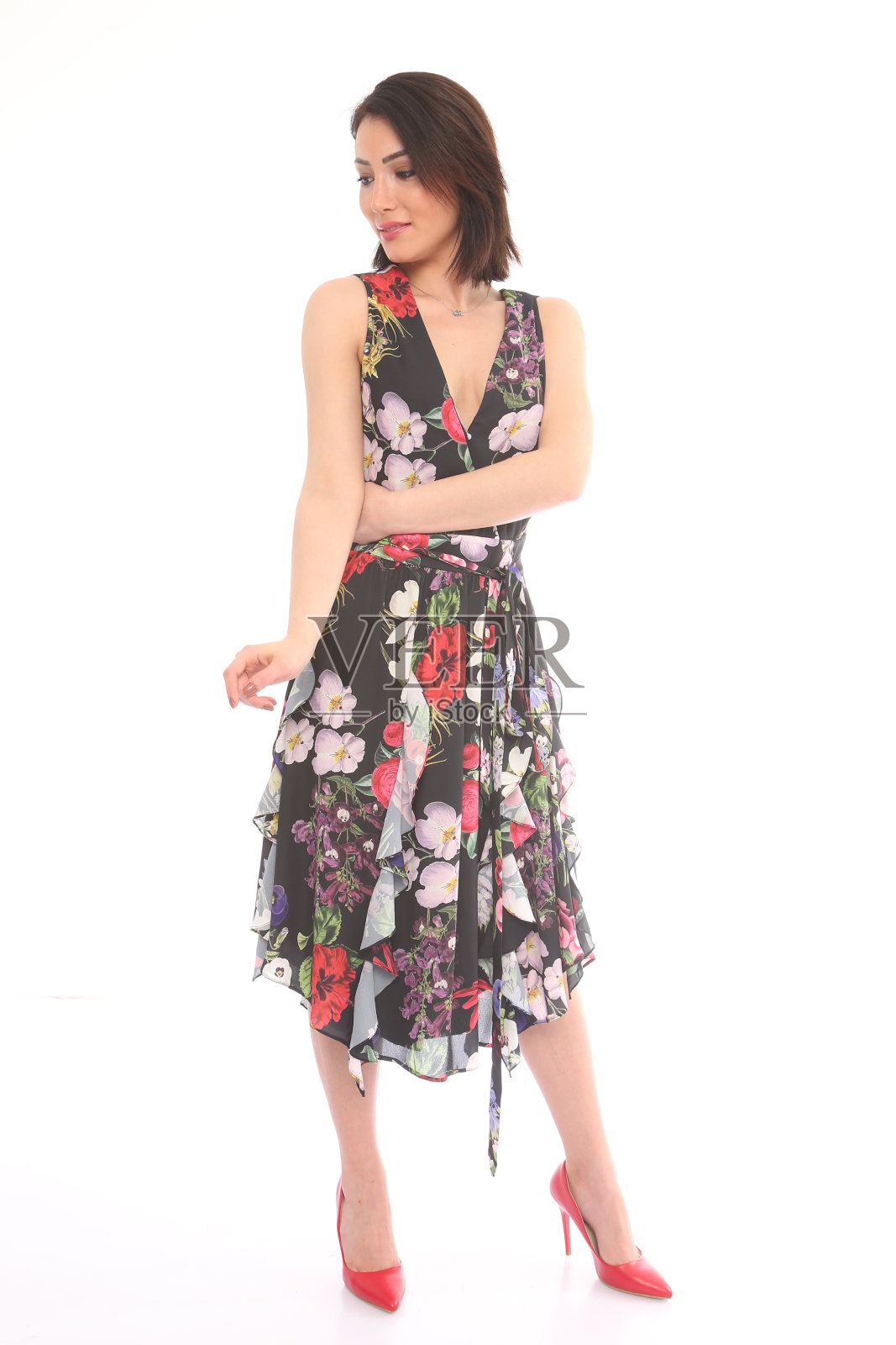 年轻美丽的女人在花图案的连衣裙前面的白色背景照片摄影图片