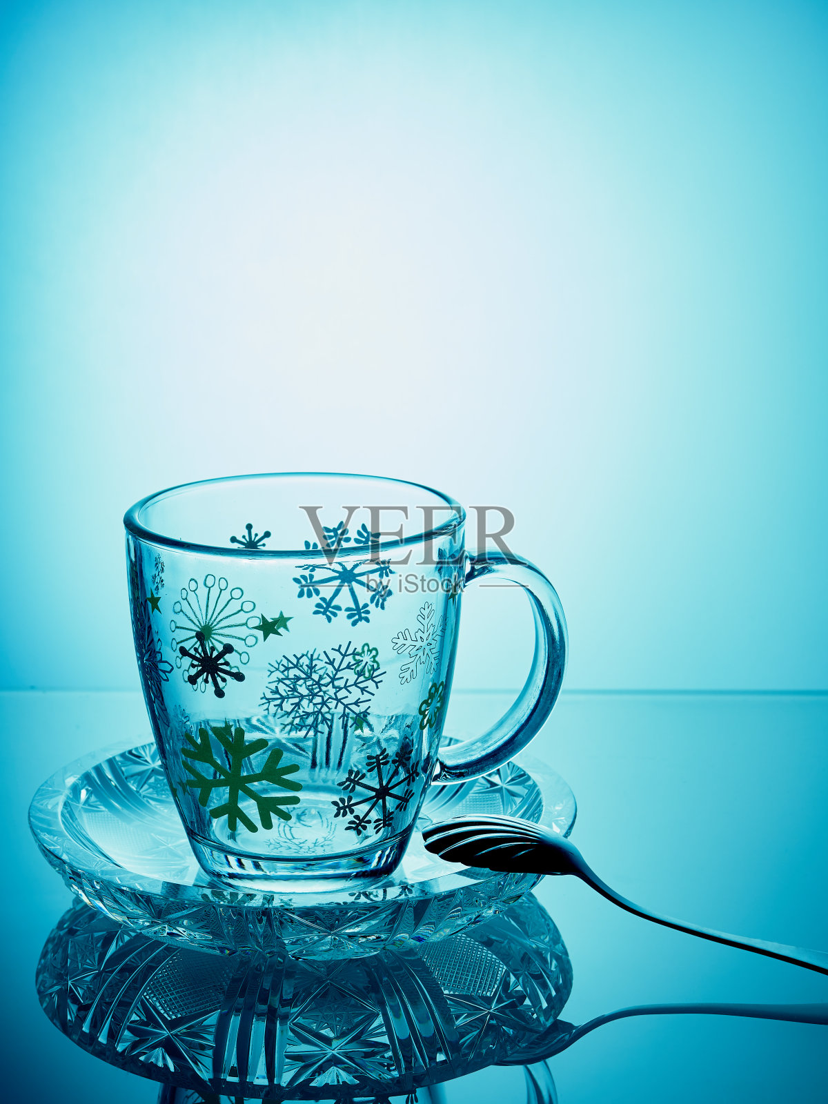 镜面反射的杯子。蓝色背景的杯子照片摄影图片