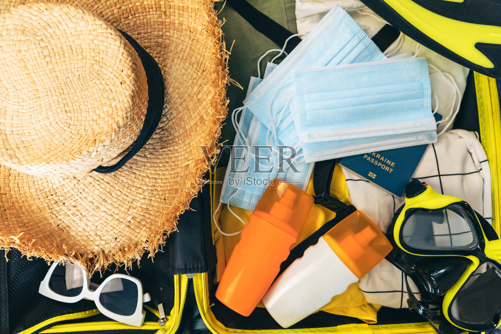 装满衣服和护照的黄色袋子，上面放着医用口罩照片摄影图片