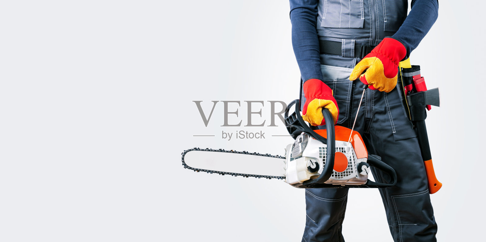 带着链锯的伐木工，灰色背景，横幅。照片摄影图片