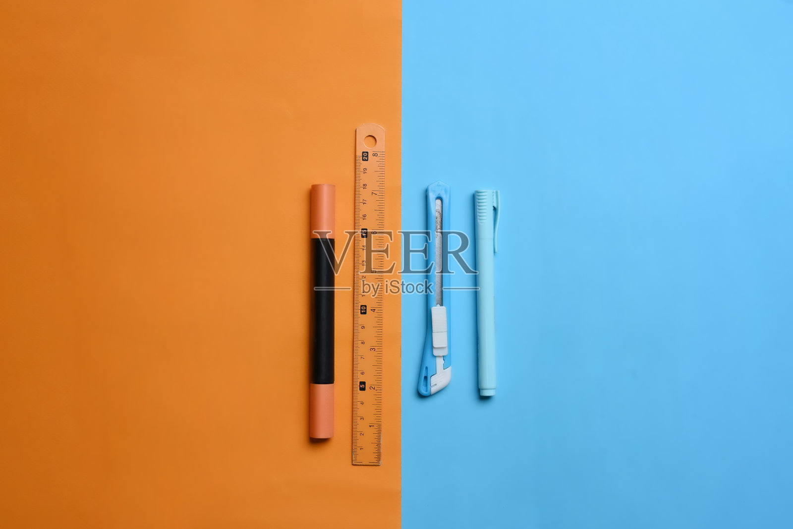 上面查看文具上的两种色调彩色桔黄色的蓝色背景。照片摄影图片