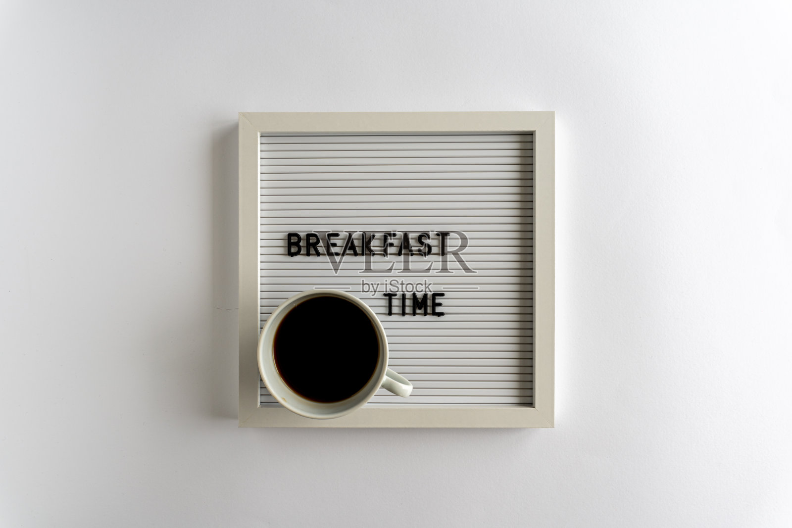 写着早餐时间的字母板，一杯咖啡，在白色的背景上照片摄影图片