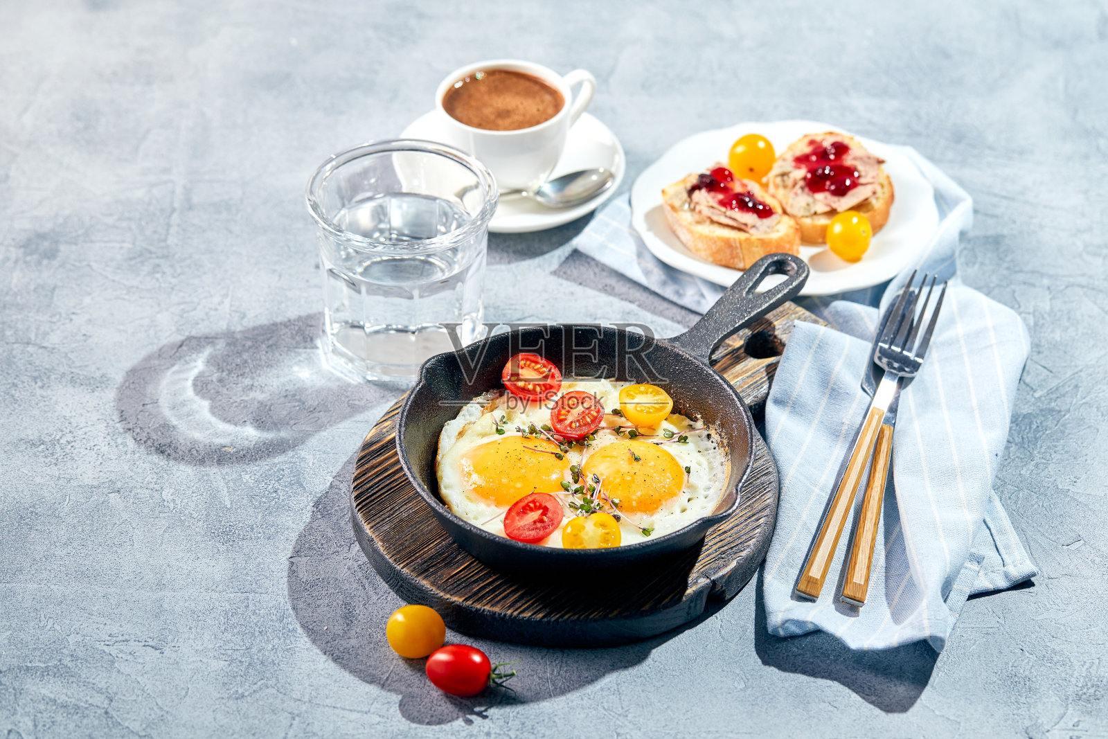 在铸铁煎锅里煎鸡蛋。阳光早餐概念照片摄影图片