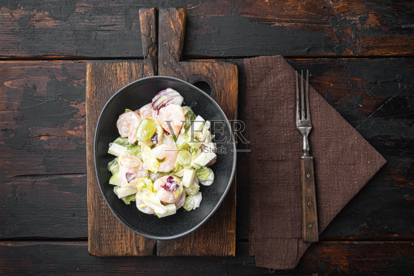 大虾华尔道夫沙拉，配酱汁苹果和葡萄，放在旧的深色木桌上，平躺着俯视图，有文字拷贝空间照片摄影图片