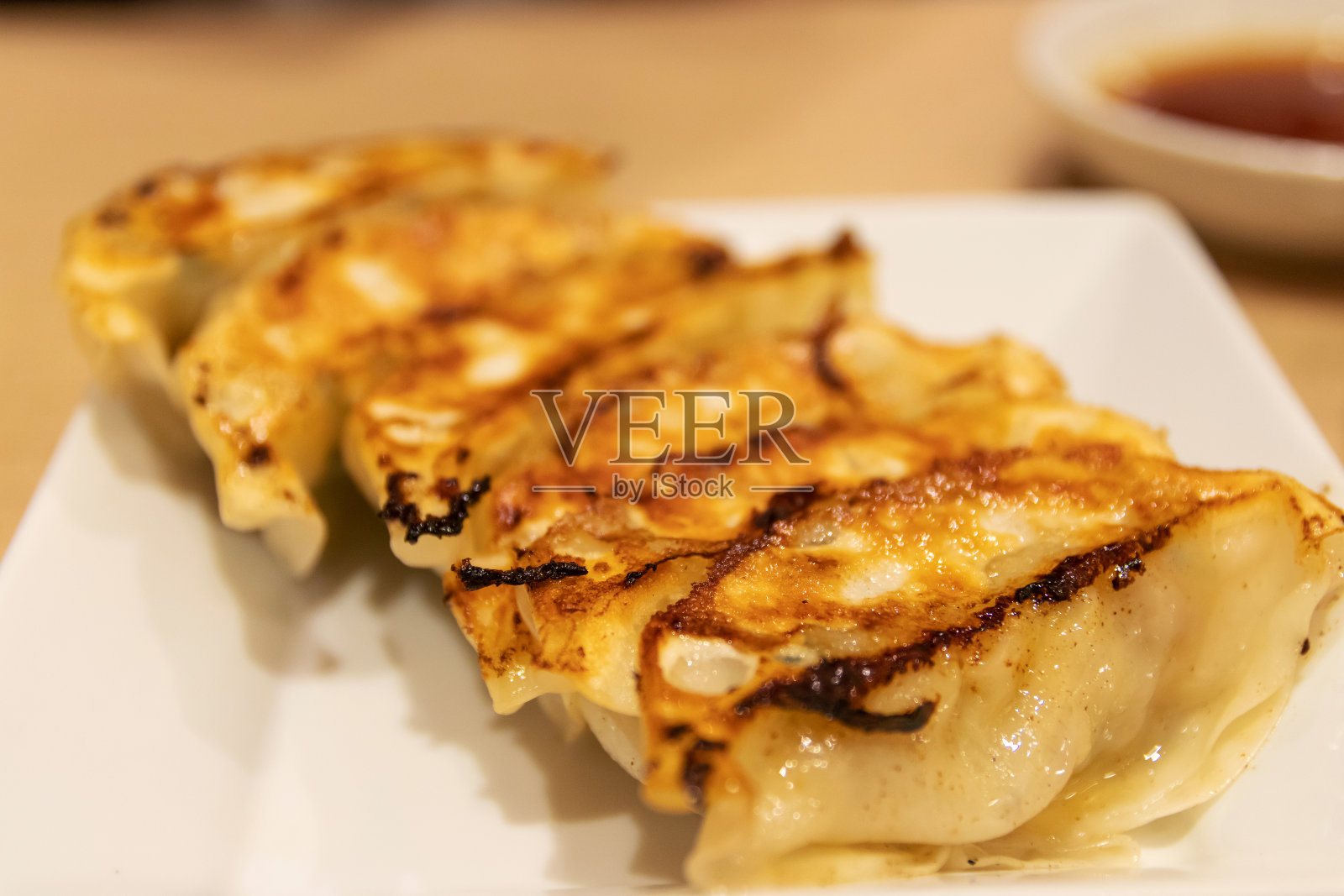 日式煎饺或日本煎饺。饺子用碎肉和蔬菜馅包在一个薄面团里。照片摄影图片