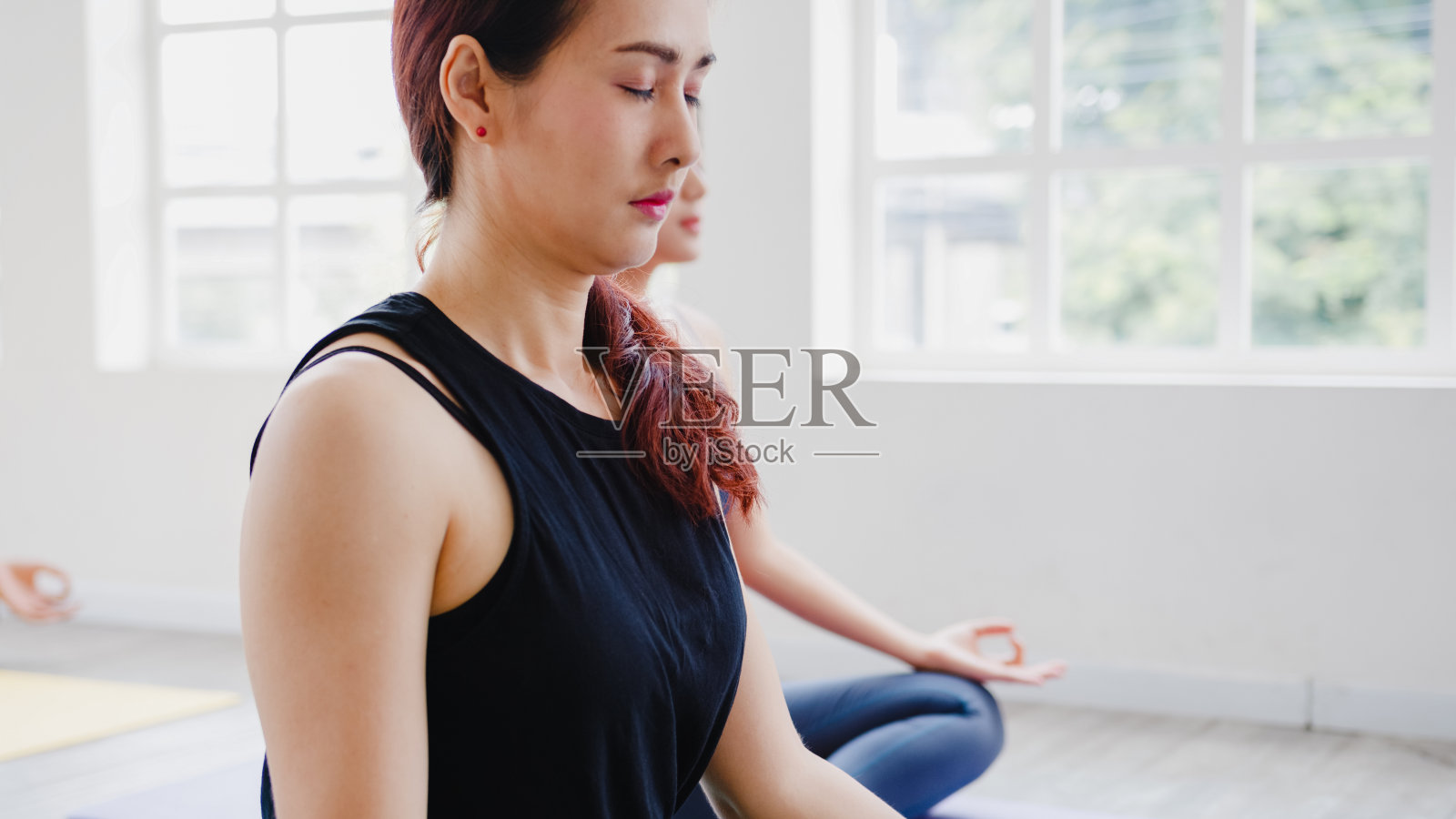 年轻的亚洲体育有吸引力的人练习瑜伽课与教练。亚洲女性群体在健身室锻炼健康的生活方式。照片摄影图片