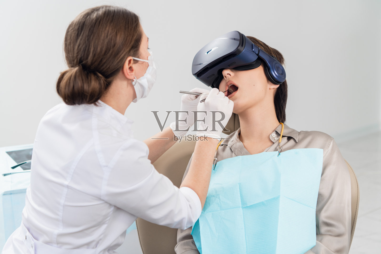 牙科医生检查她的病人的牙齿在牙科的c照片摄影图片