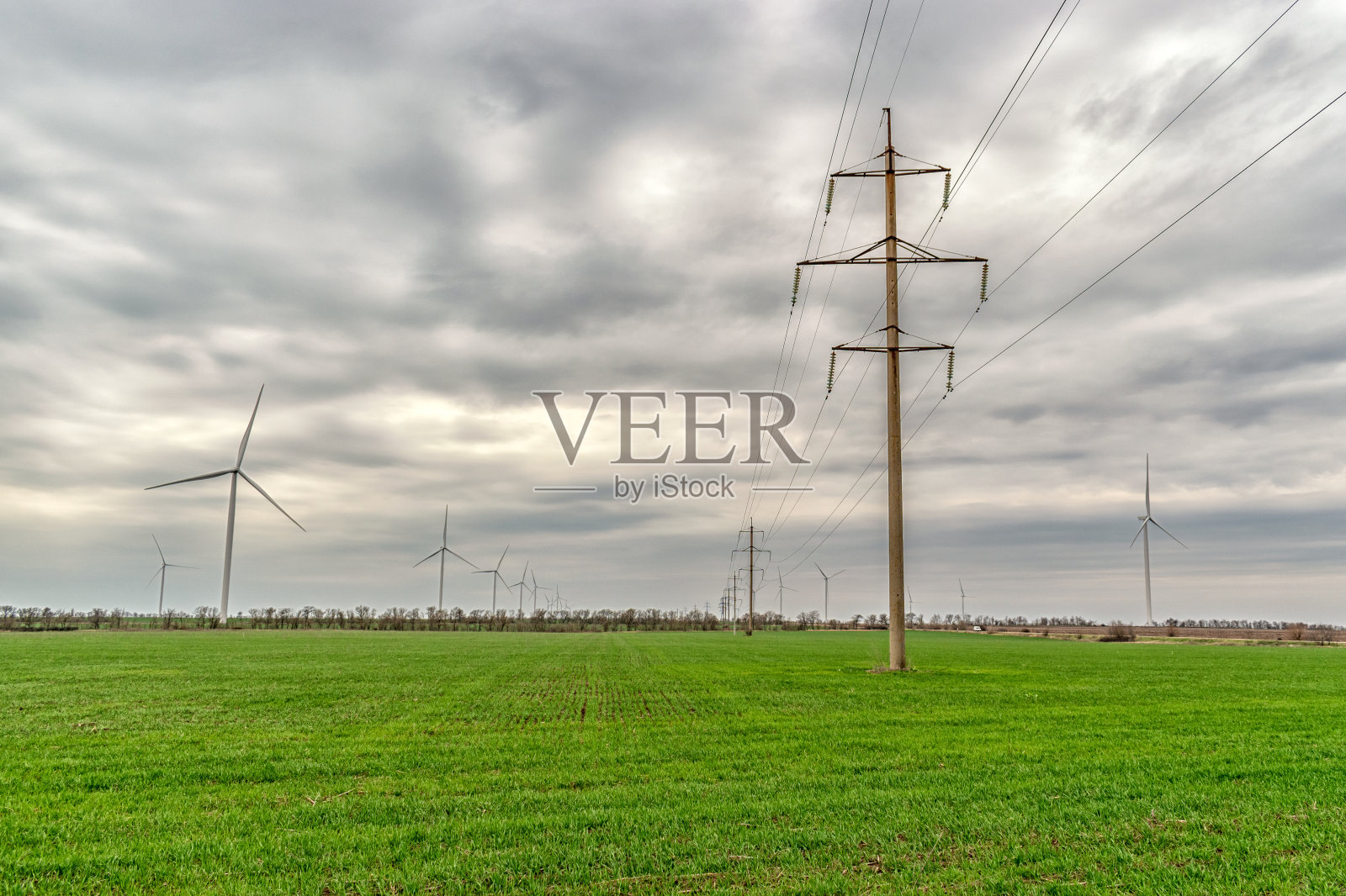 风力涡轮机在绿色的田野里发电。绿色发电理念。照片摄影图片