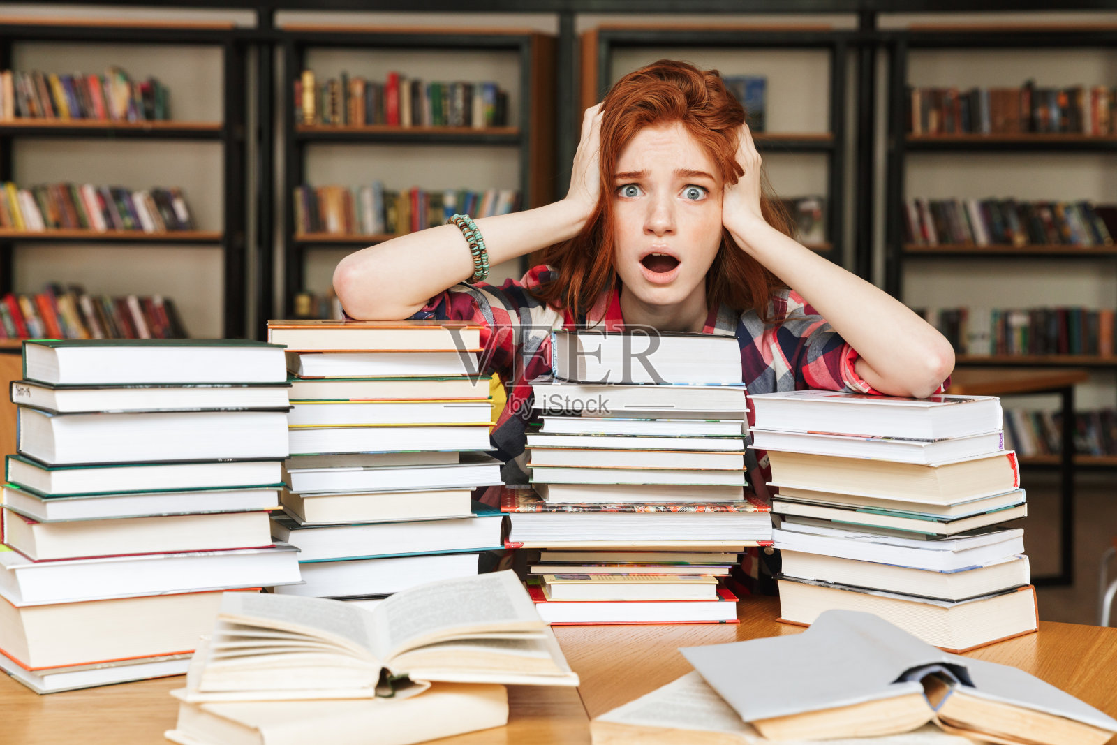 绝望的少女坐在图书馆里照片摄影图片