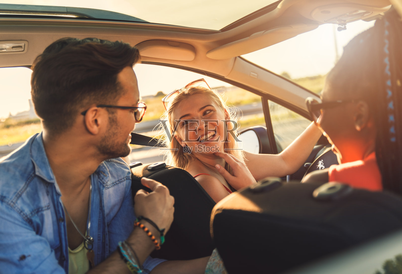 三个最好的朋友在车里享受假期旅行。照片摄影图片