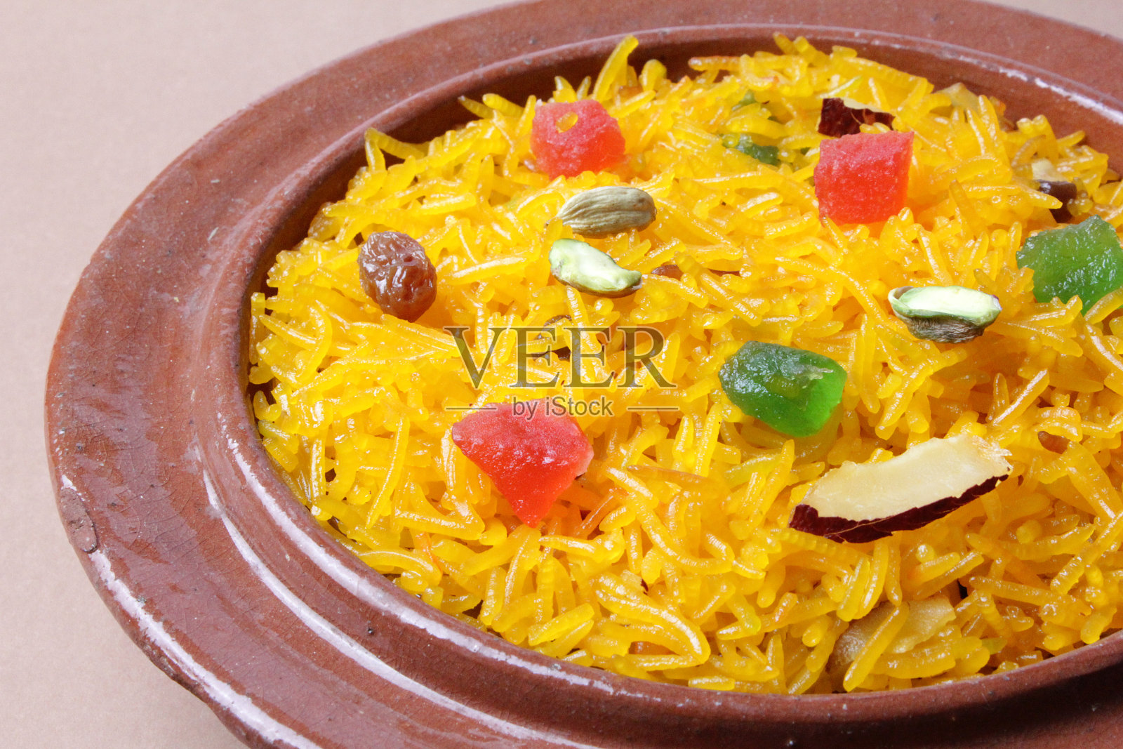 美味的扎尔达米饭，白色背景上的粘土碗中的印度甜米饭甜点。照片摄影图片