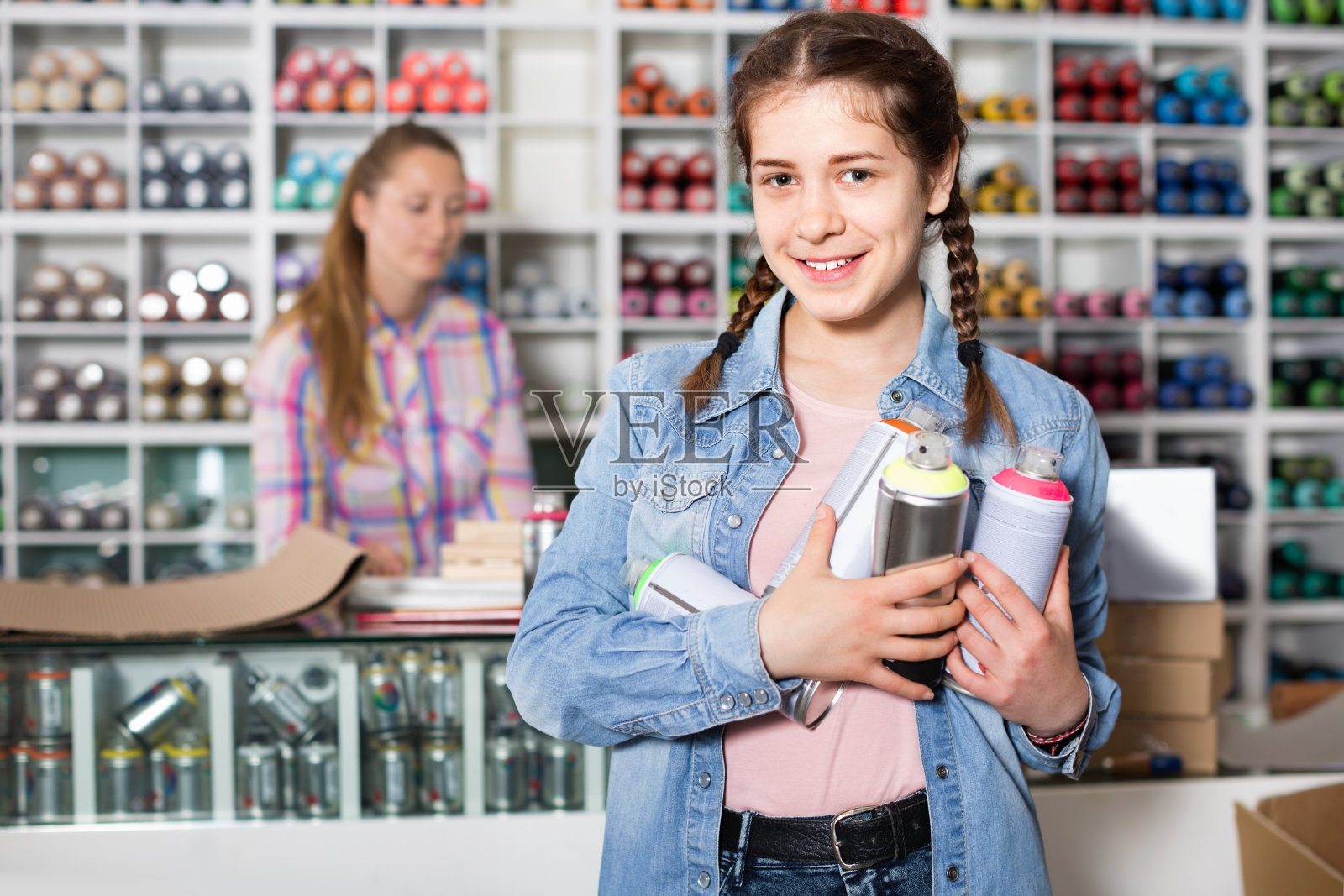 肖像女孩选择油漆颜色的喷雾器在艺术商店照片摄影图片