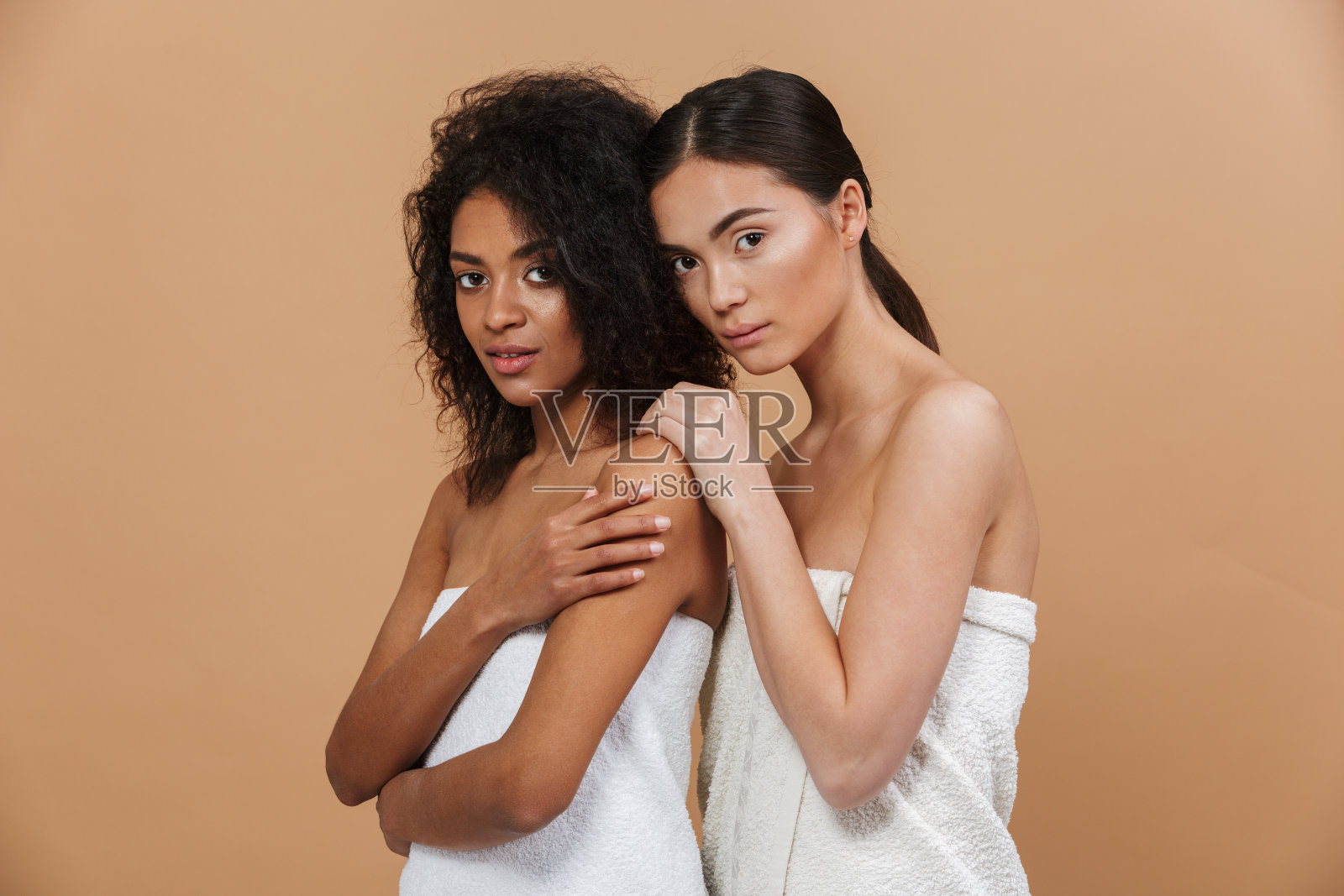 美丽的肖像两个多民族半黑女模特，非洲裔美国和亚洲女性没有化妆，一起摆出孤立的米色背景照片摄影图片