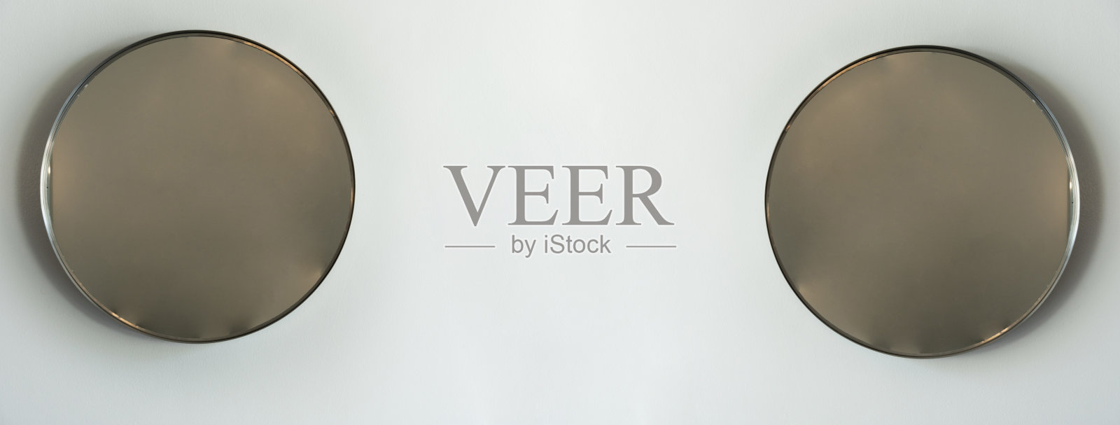 白色水泥墙背景上的两面圆镜照片摄影图片