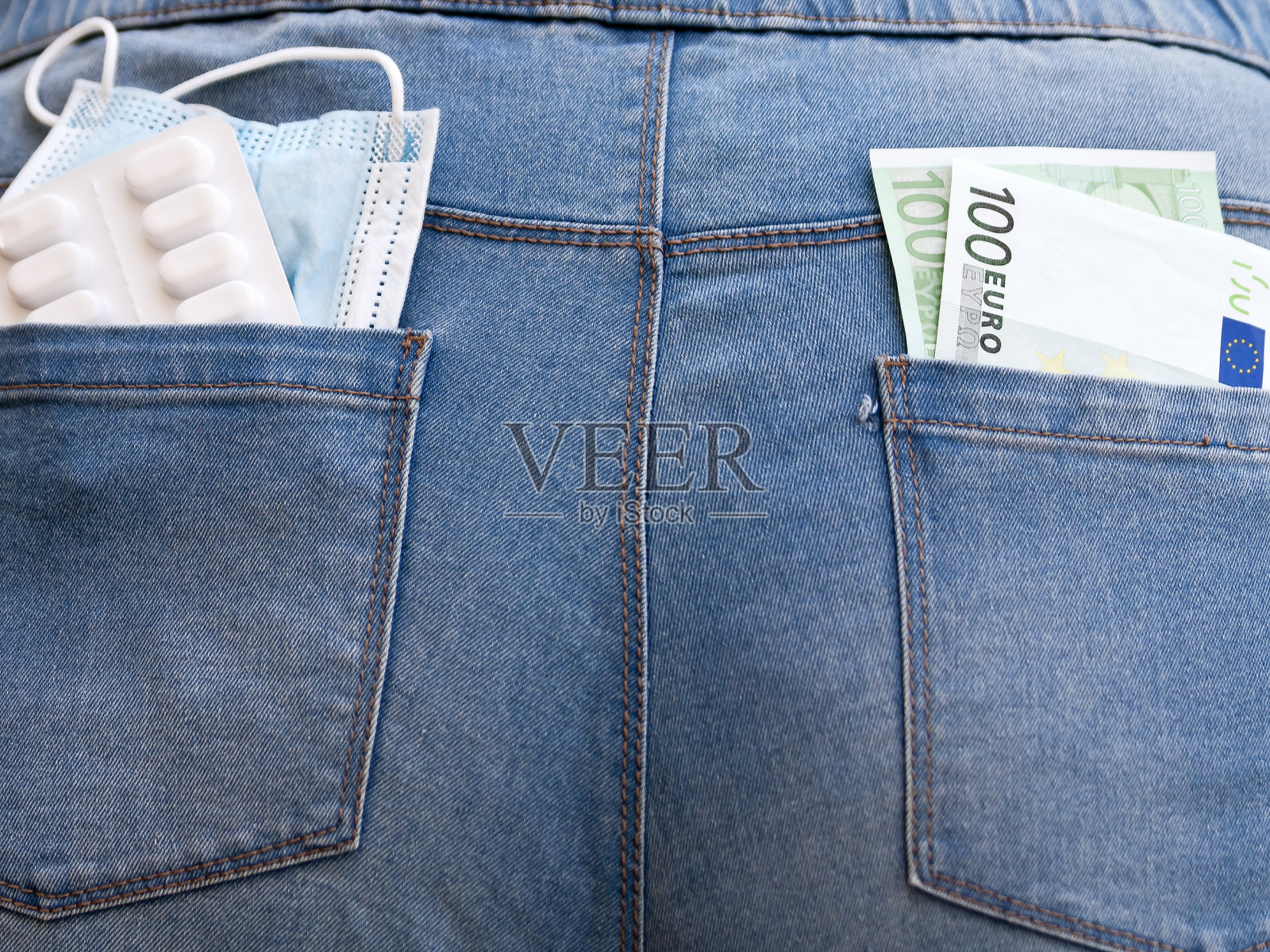 牛仔裤口袋里装着面罩，药片和钱照片摄影图片