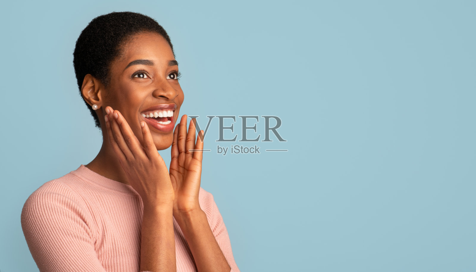 快乐兴奋的黑人妇女的肖像，用惊讶触摸脸照片摄影图片