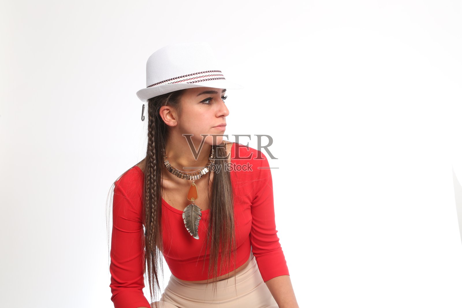 年轻漂亮的女人，穿着红衬衫，戴着白帽子，戴着白项链照片摄影图片