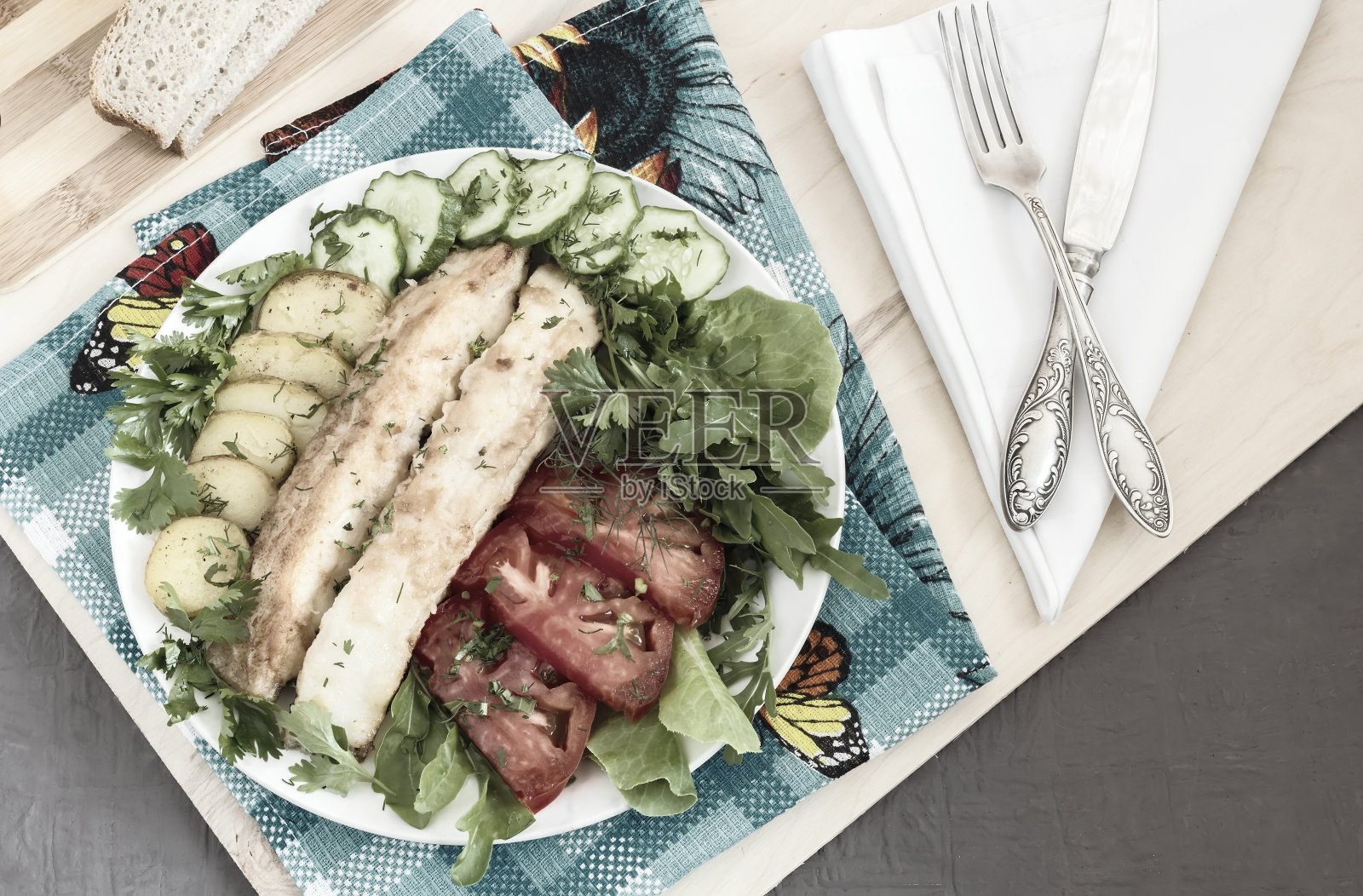 炸鱼配土豆、蔬菜和香草照片摄影图片