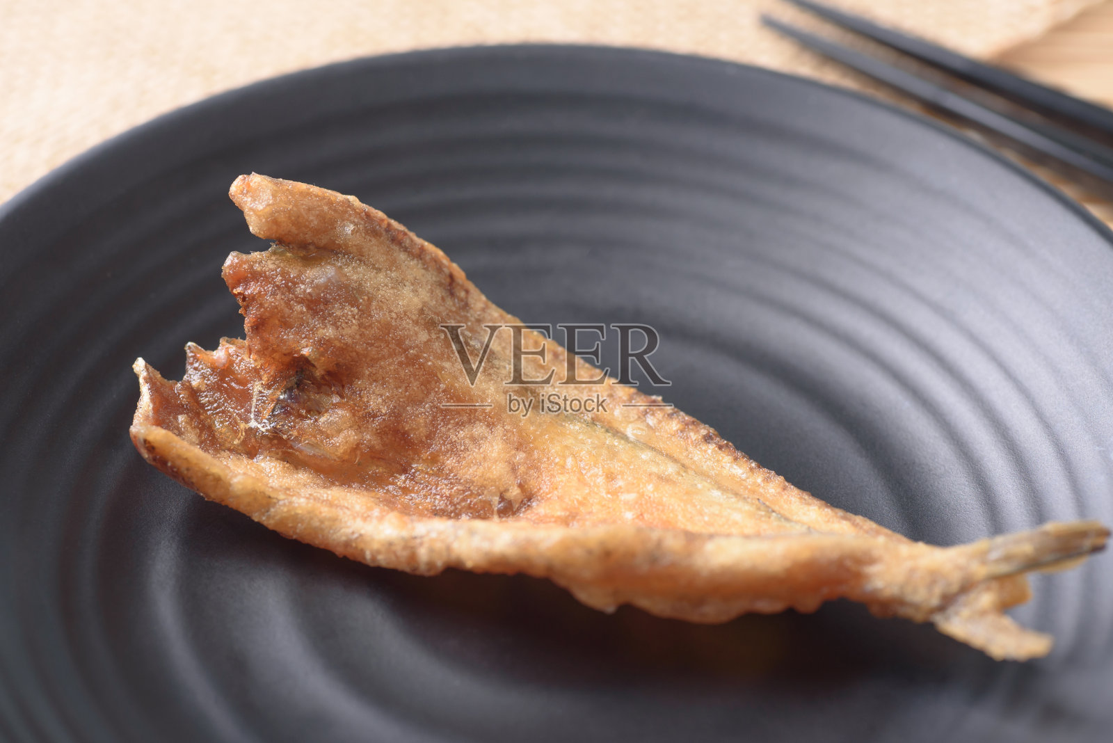 黑盘炸鱼干照片摄影图片