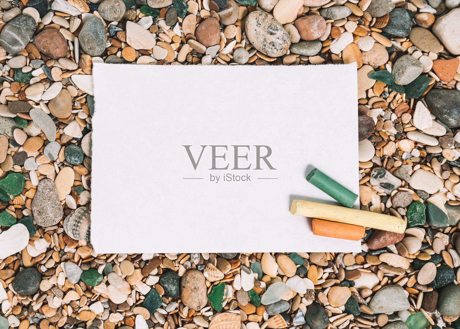 夏日背景，卵石滩白色纸与蜡笔。照片摄影图片