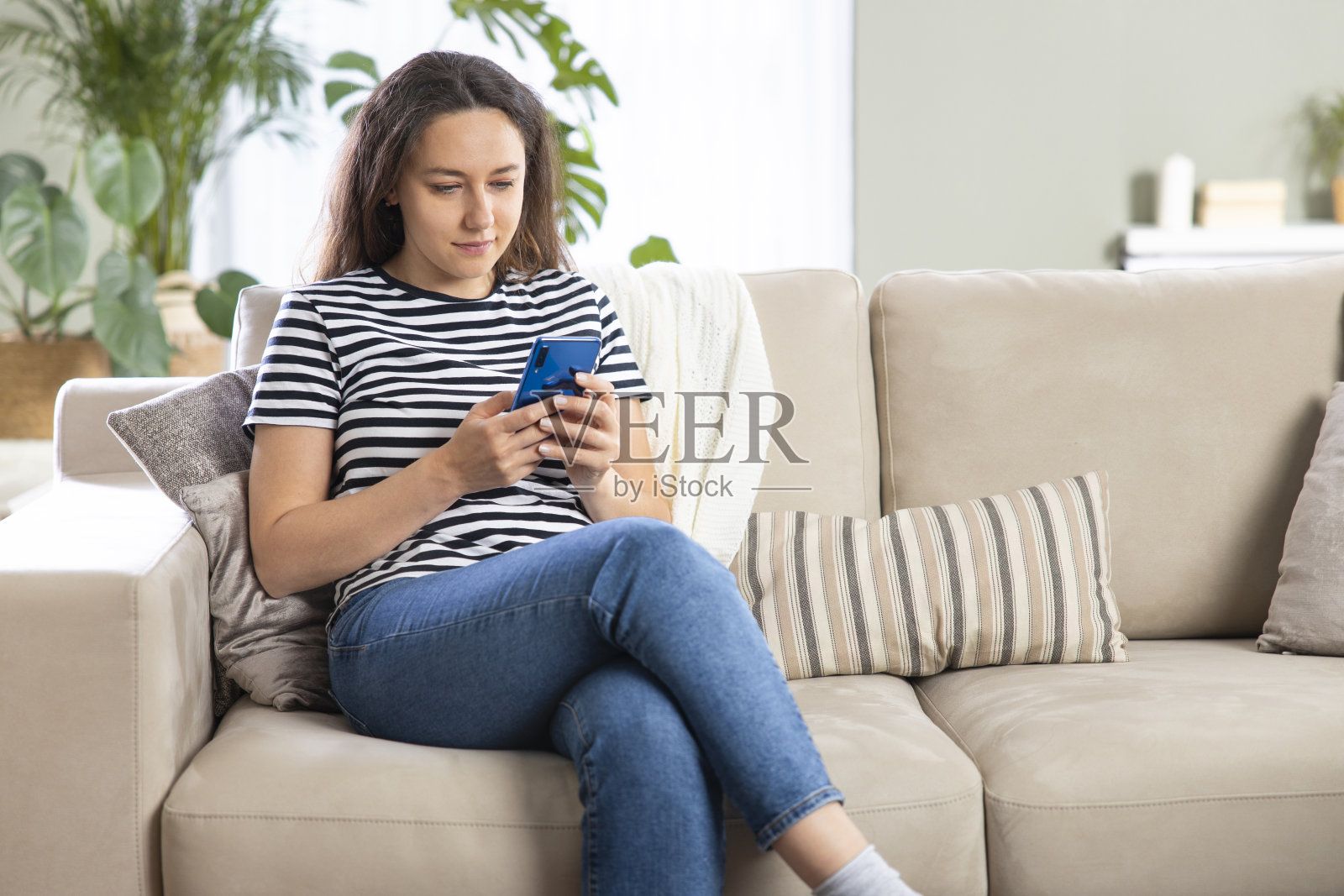 年轻女子在家里使用电话照片摄影图片