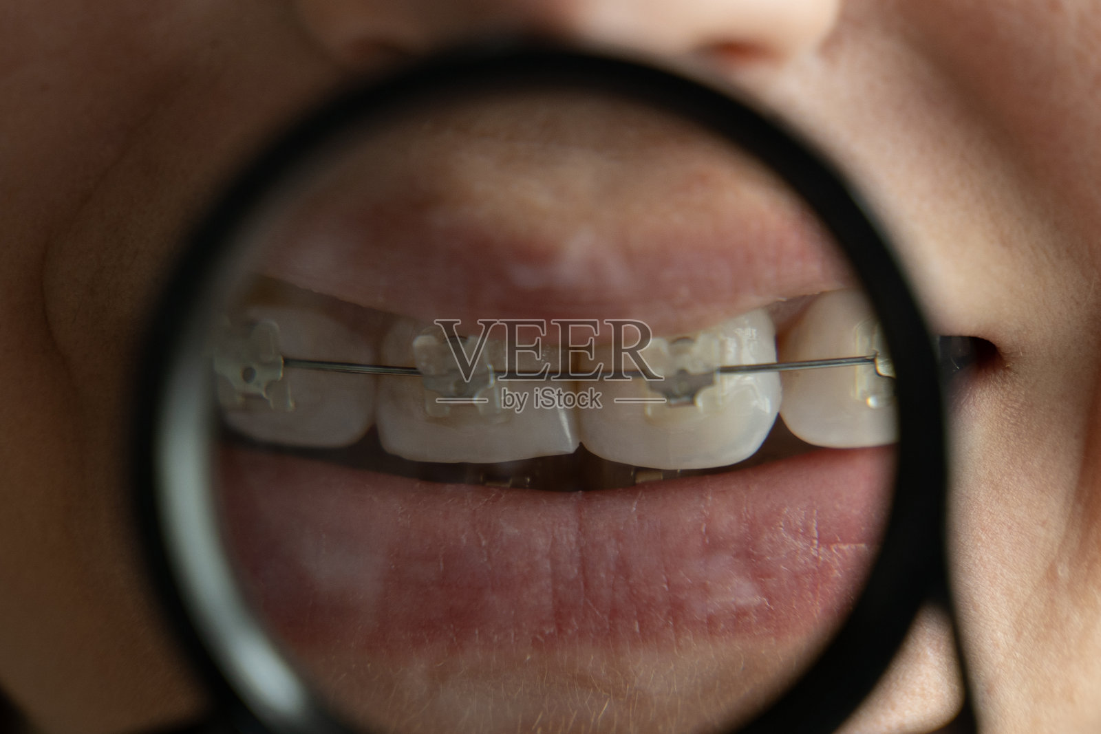 女人在放大镜中展示她的背带照片摄影图片