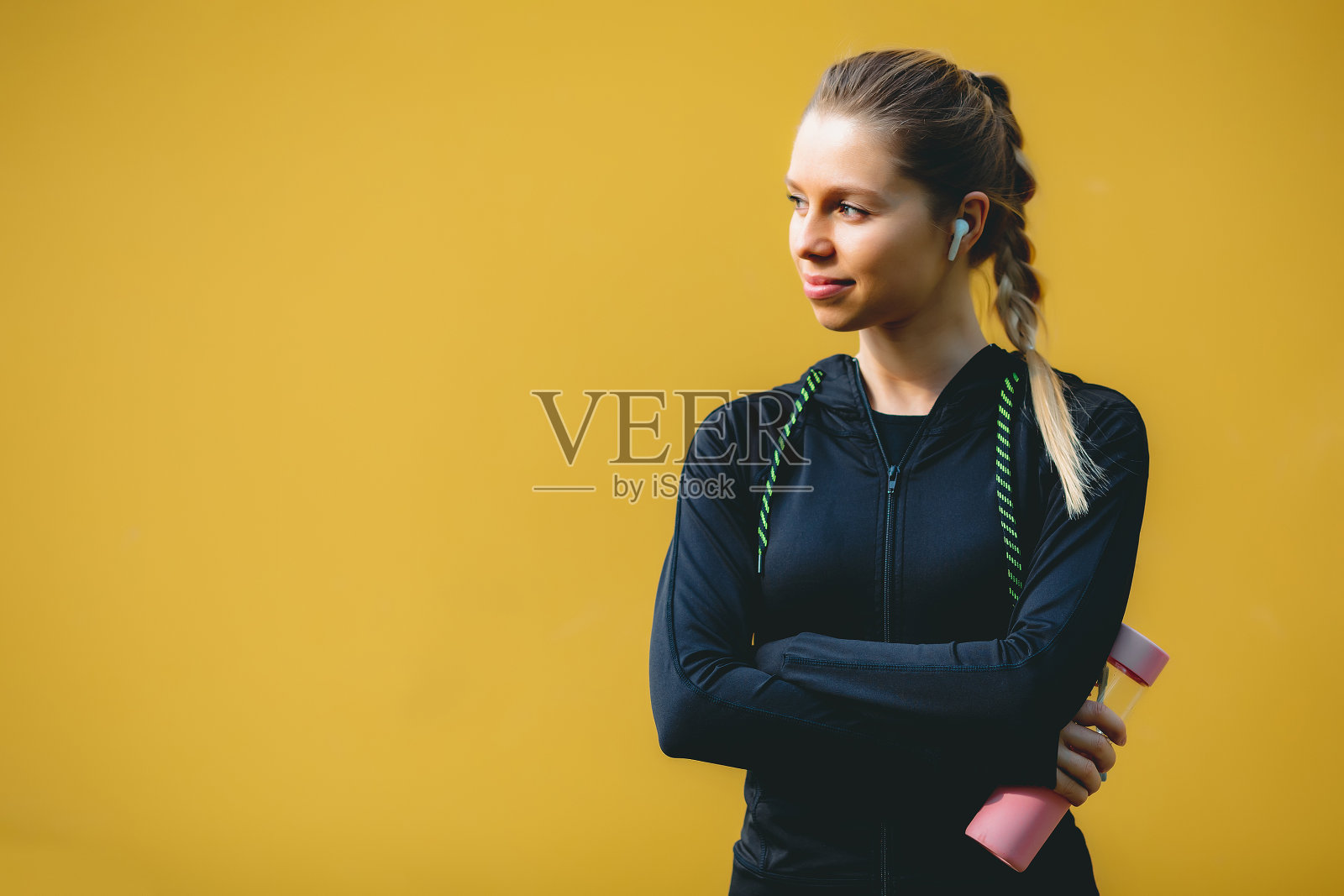 迷人的女孩用她的手机，无线耳机在公园里跑步照片摄影图片
