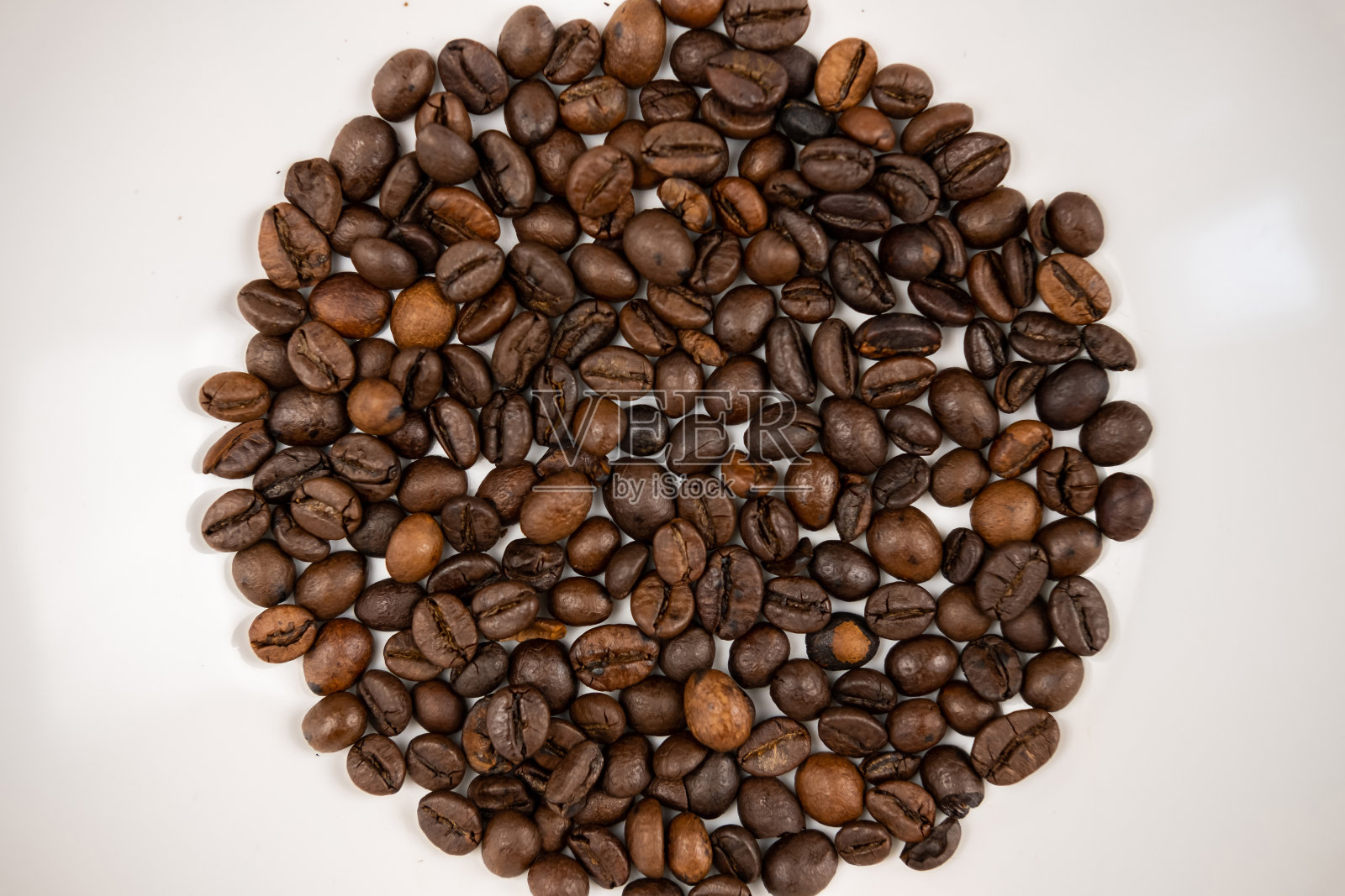 在白色背景下烘焙咖啡豆。照片摄影图片