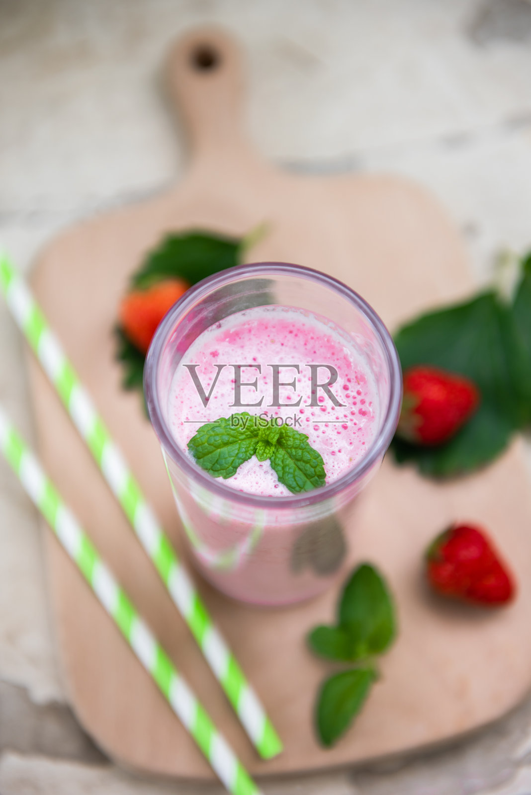 一杯新鲜草莓奶昔。草莓冰沙配新鲜草莓照片摄影图片