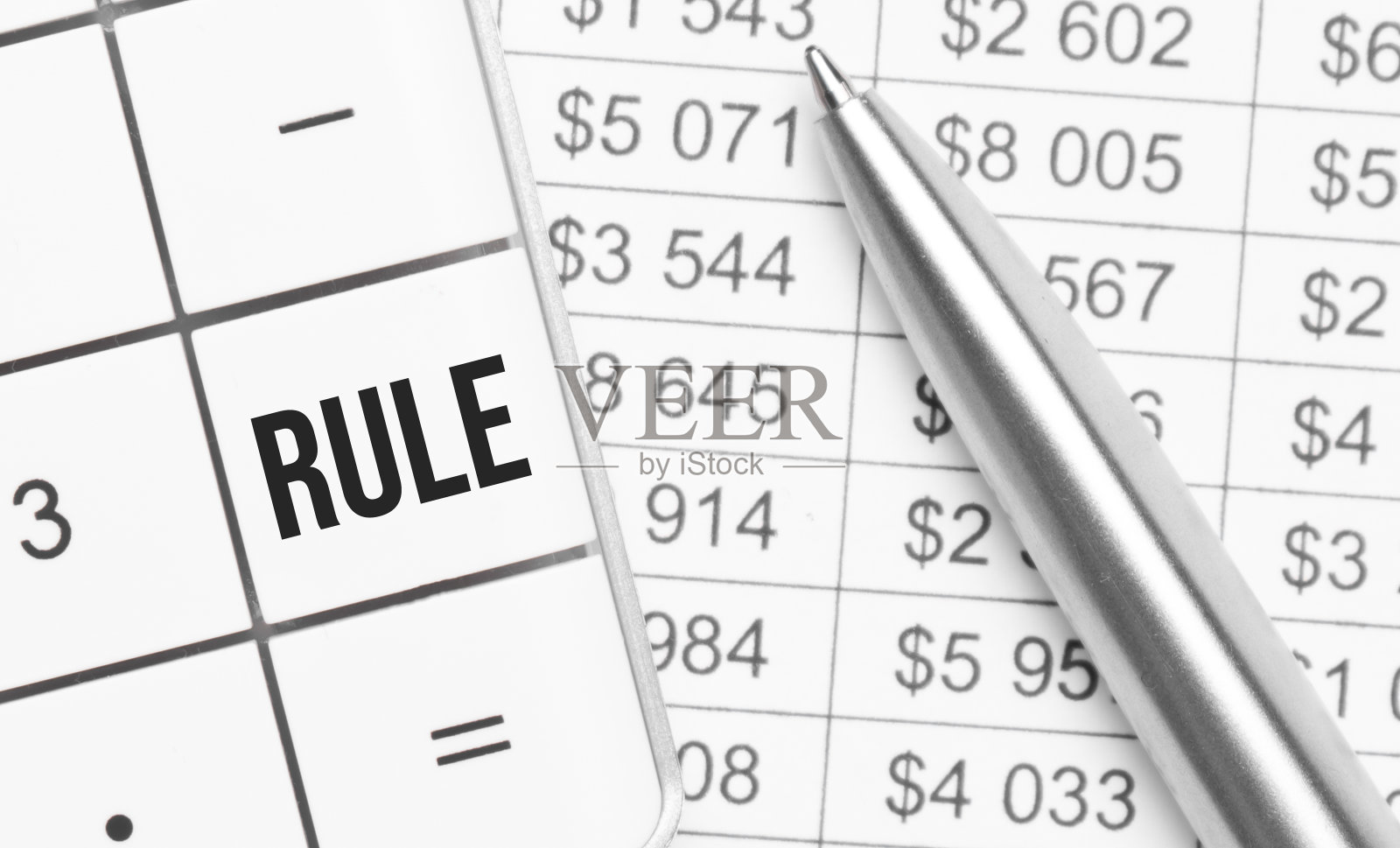 商业和金融。在桌子上有一份报告，一支钢笔和一个计算器，它的大键上写着:规则照片摄影图片