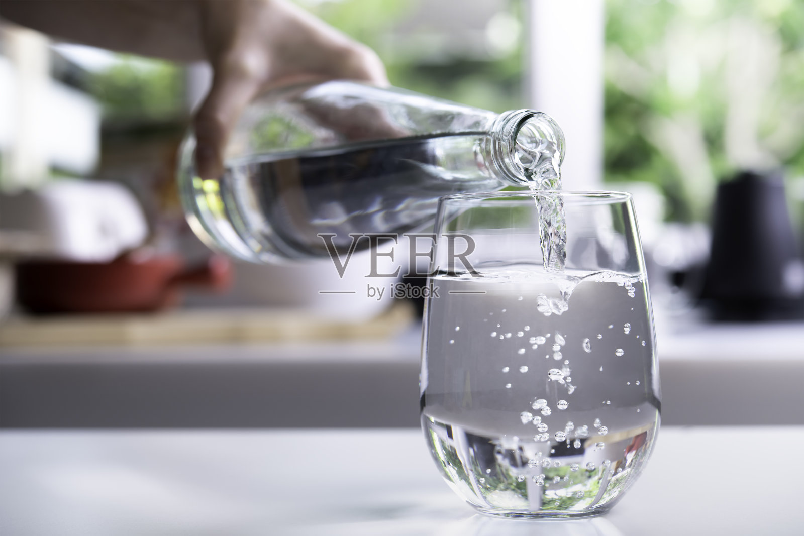 把水倒进厨房的玻璃杯里照片摄影图片