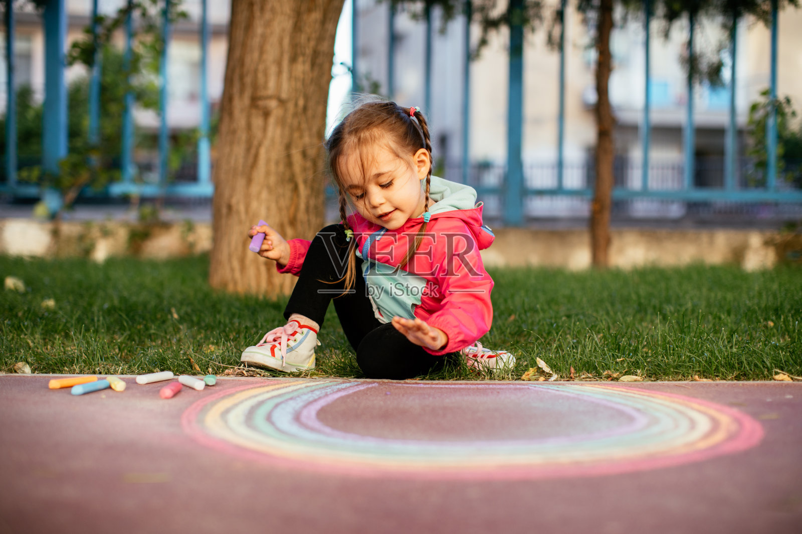 女孩在人行道上用粉笔画彩虹照片摄影图片