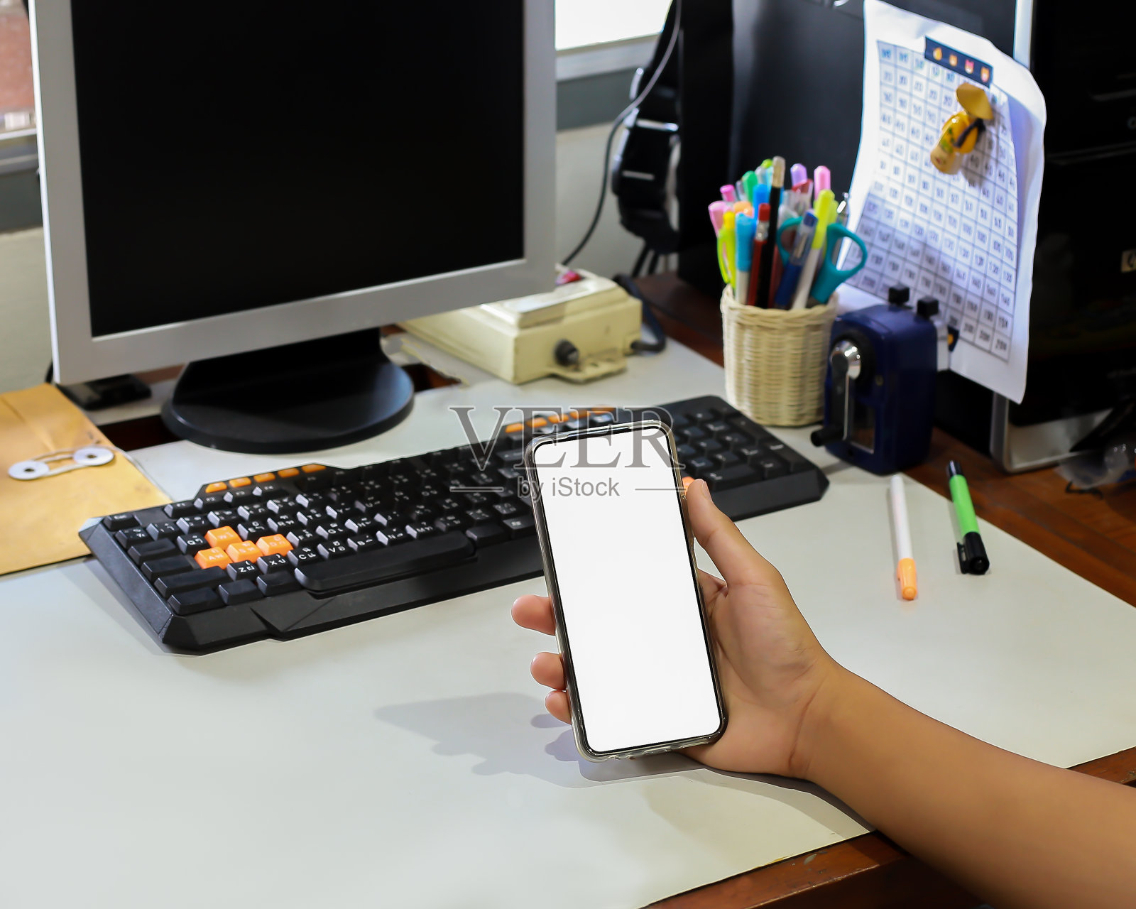 一款拥有创意白色屏幕的智能手机，背景是一片电动风力涡轮机。照片摄影图片