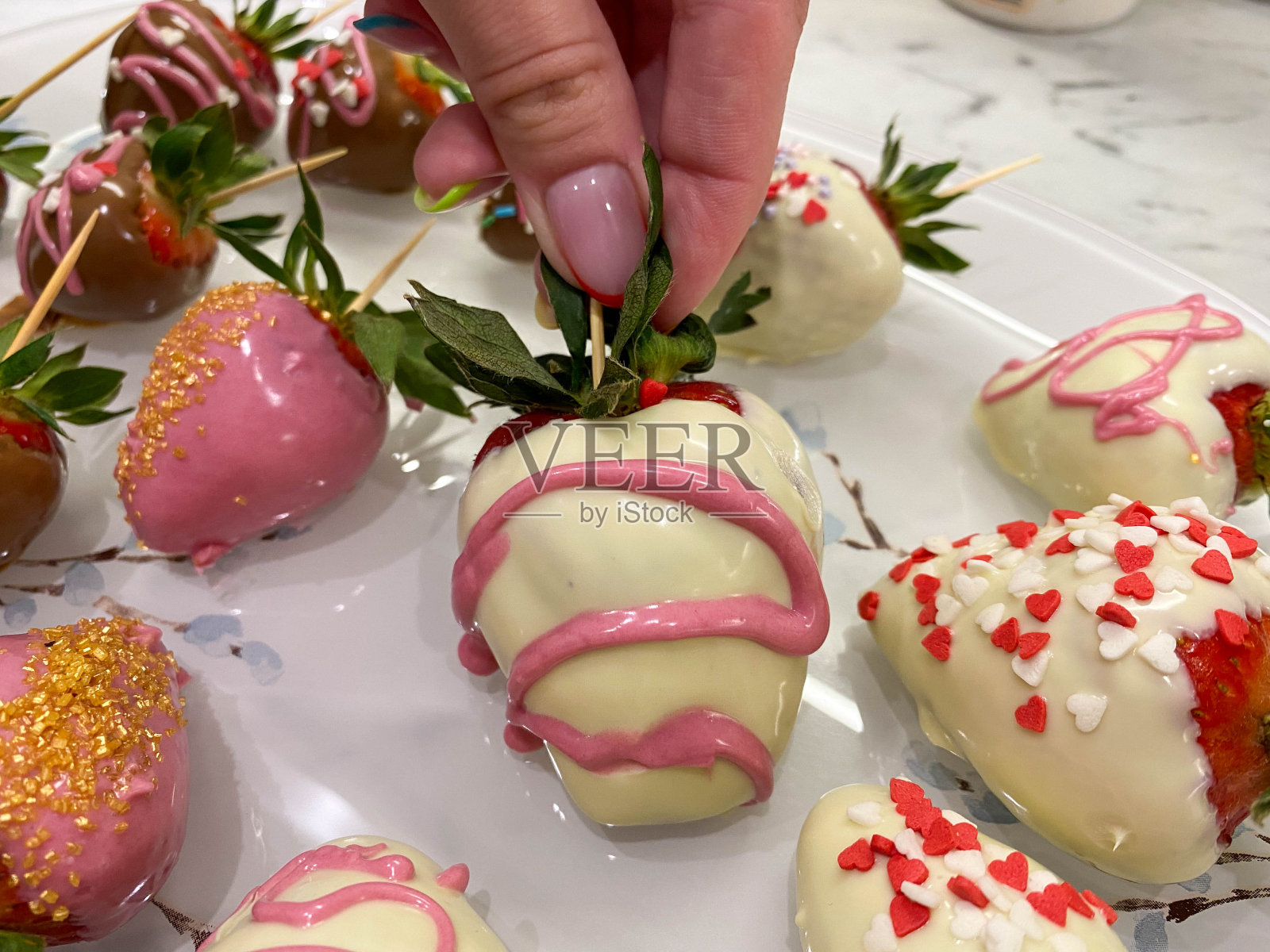 美丽，鲜艳，美味，甜美，多汁，新鲜的各种草莓在篡改白和黑牛奶比利时巧克力装饰和装饰。一个浪漫的甜点作为礼物照片摄影图片