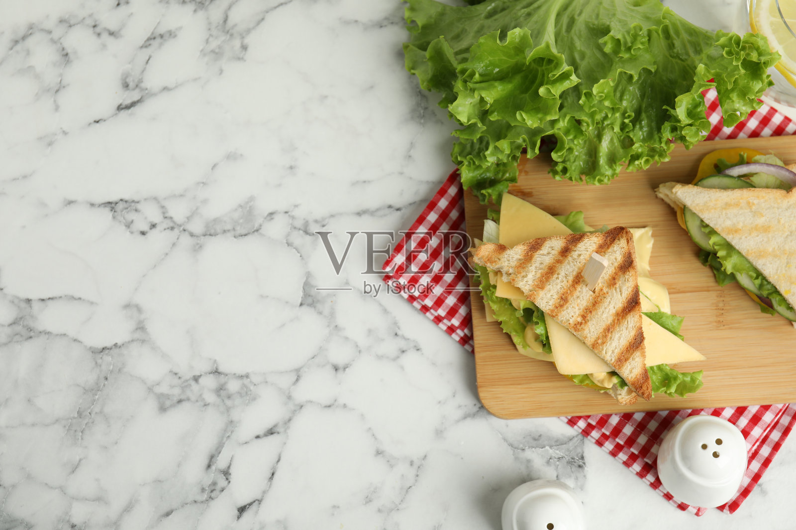 木板和美味的三明治放在白色大理石桌上，平躺着。空间的文本照片摄影图片