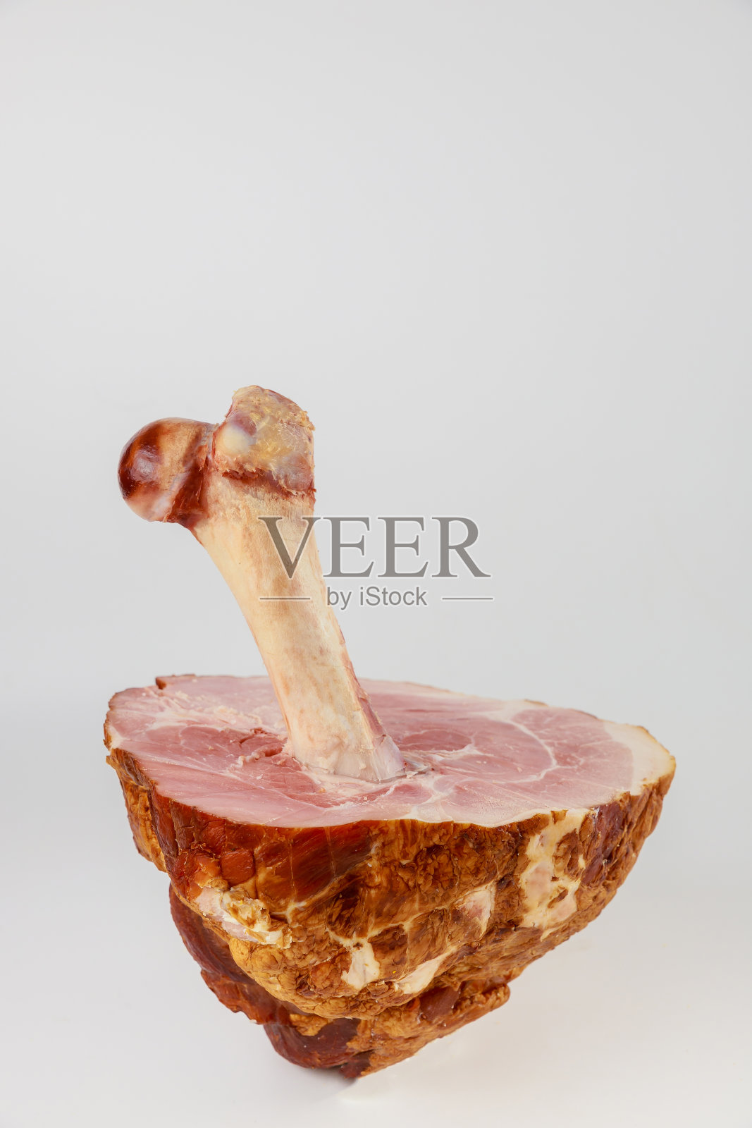 在白色孤立的背景上切开火腿的骨头。照片摄影图片