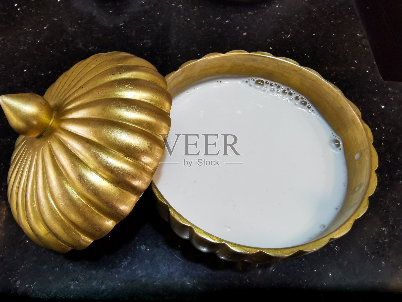 一个装有椰奶的黄铜容器照片摄影图片