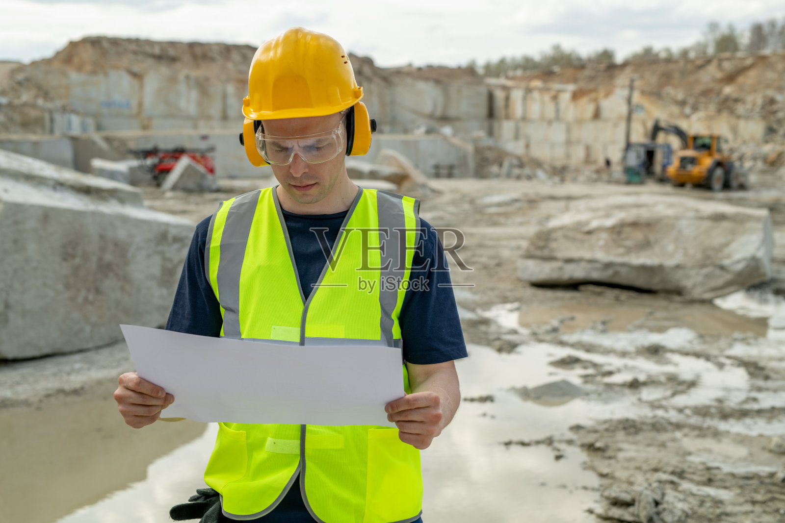 认真的建设者在保护耳机和头盔照片摄影图片