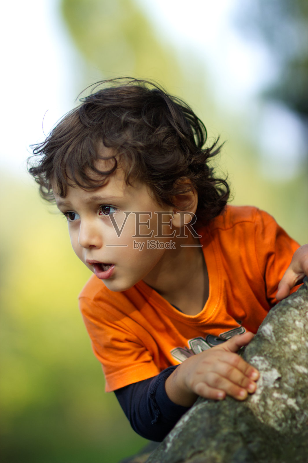 特写的肖像，一个美丽的小男孩3-4岁在一个公园的阳光下，童年的概念照片摄影图片