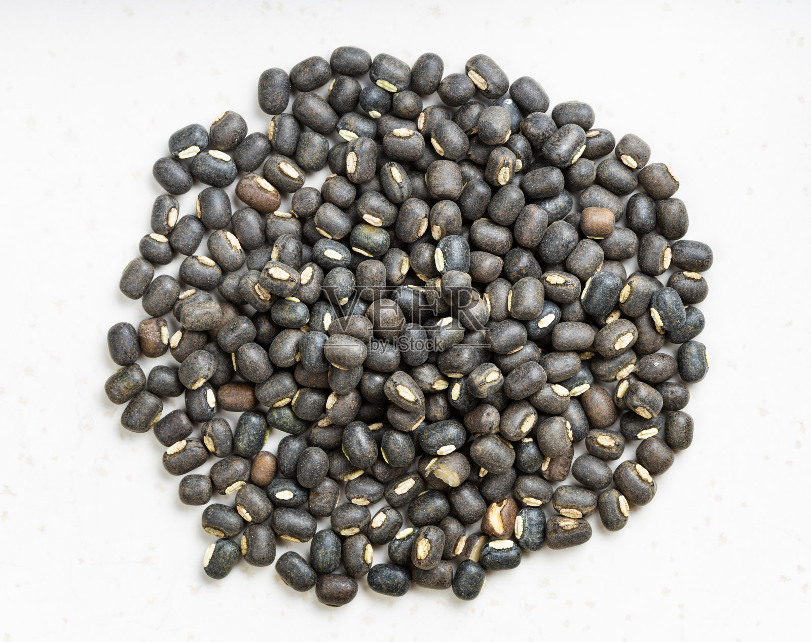 一堆黑色的乌拉德豆紧挨着灰色的照片摄影图片