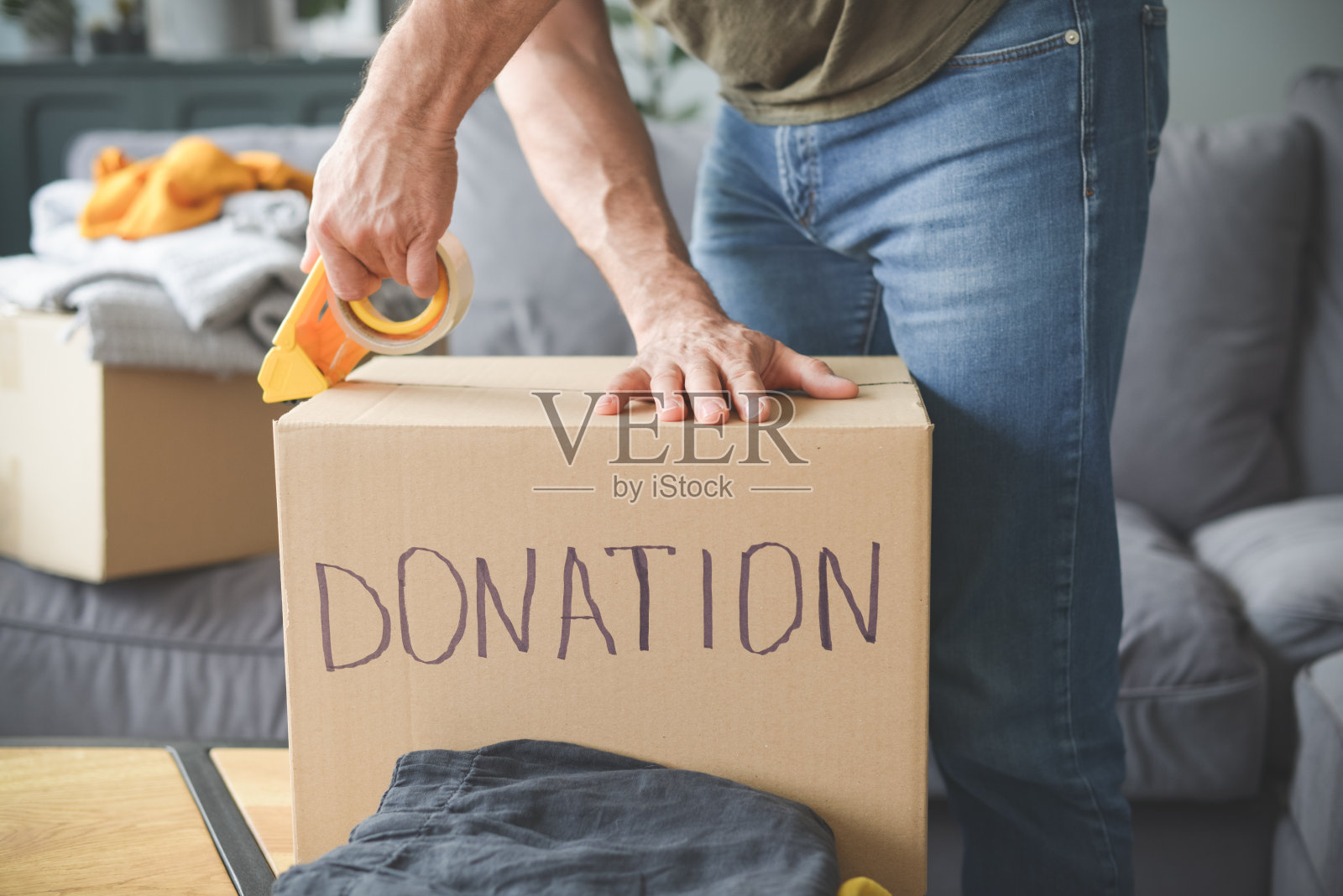 一个成熟的成年人把捐款放进盒子里照片摄影图片