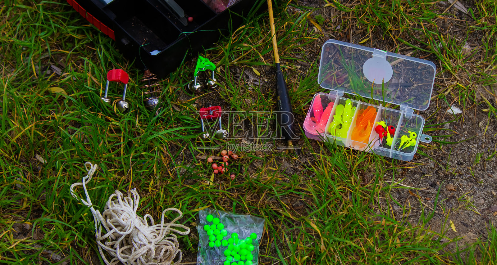 草地上钓鱼用的钓竿及附件。有选择性的重点。照片摄影图片