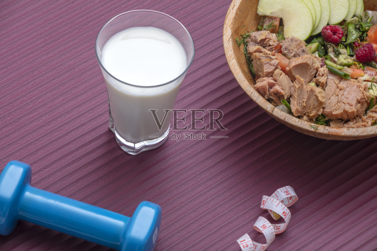 健康饮食和运动背景:新鲜健康沙拉，哑铃和卷尺照片摄影图片