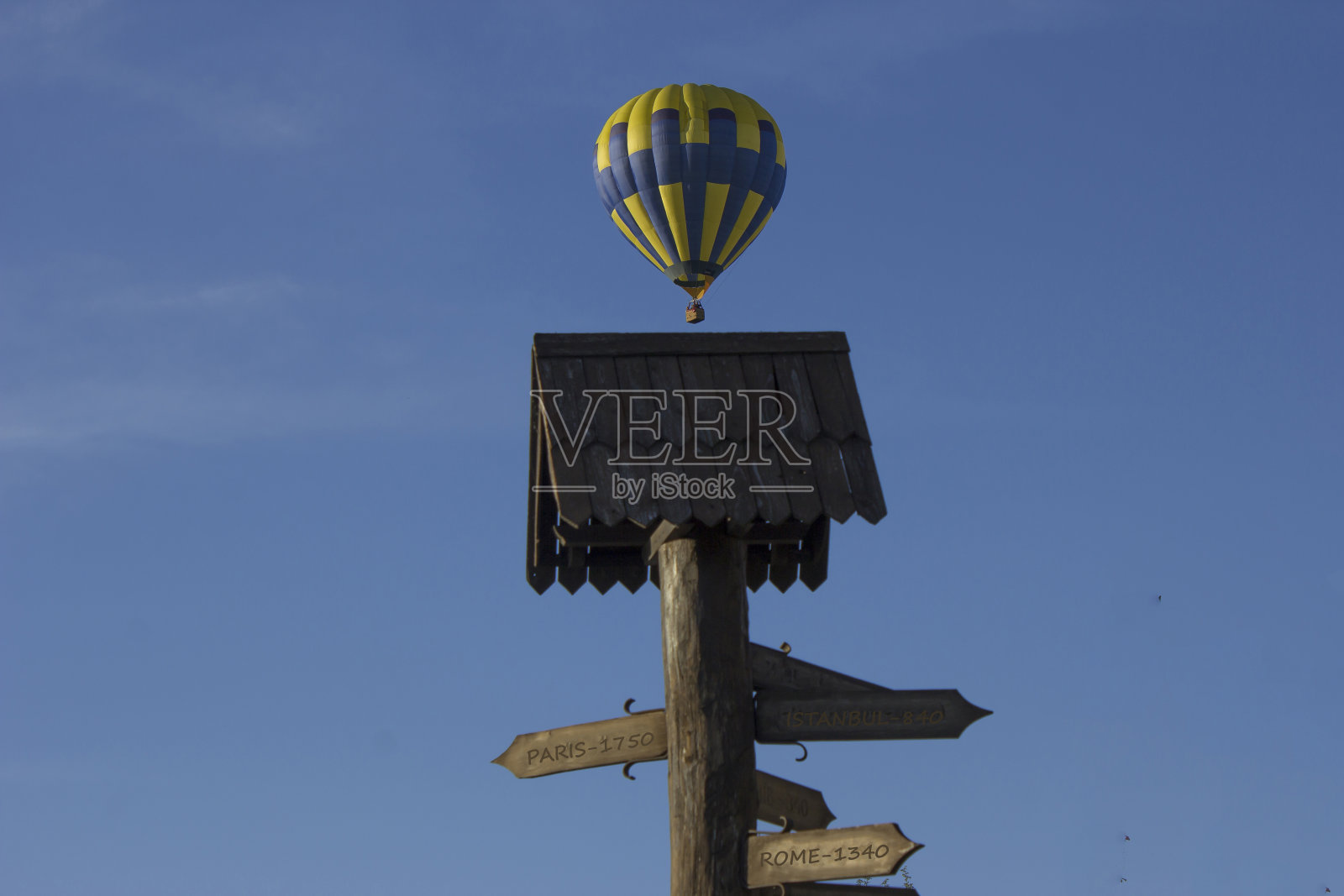 一个热气球在天空中盘旋，背景是一个方向标志照片摄影图片