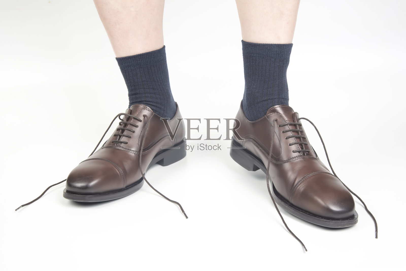 男人的腿在袜子和棕色经典鞋在白色的背景照片摄影图片