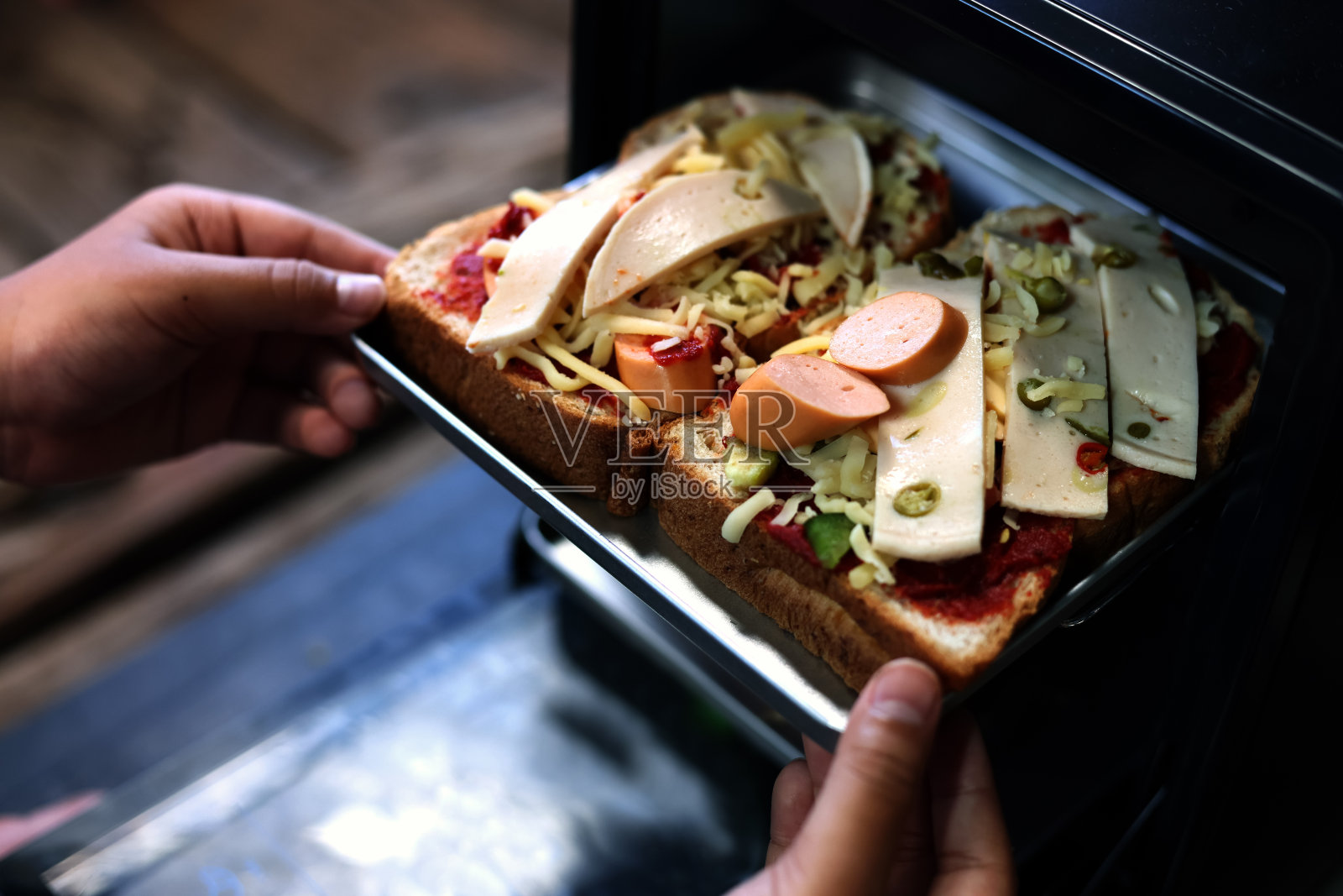 俯视图披萨年轻人在家准备披萨，居家理念。准备披萨放在厨房的烤箱里照片摄影图片